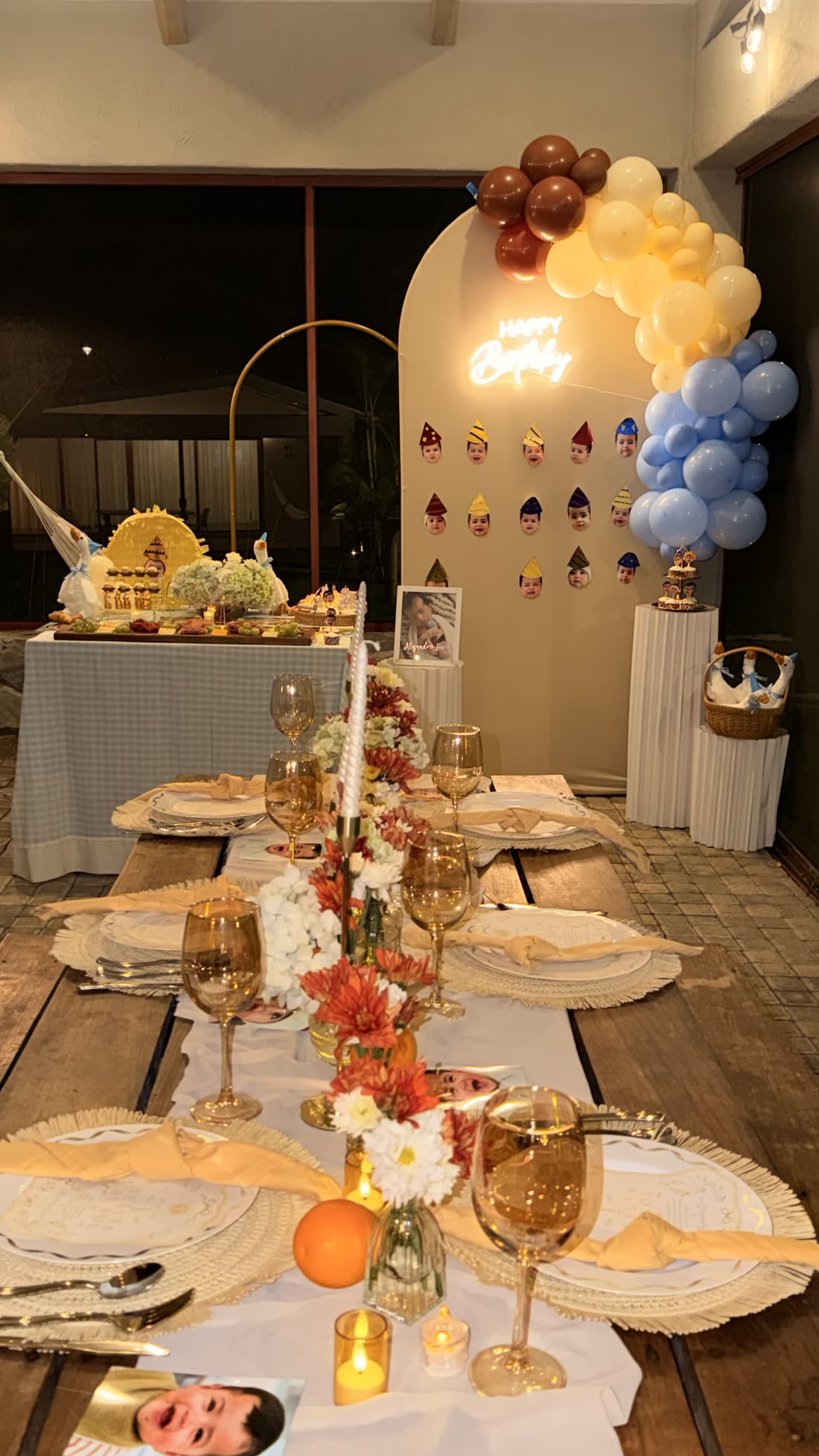 Mesa interior de celebración con guirnalda de globos azules y detalles cálidos de ETERIA.