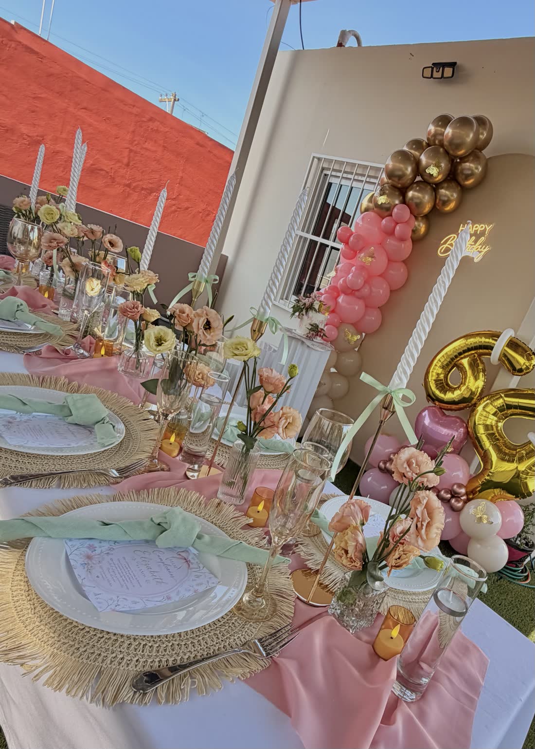 Mesa de evento con decoración rosa, cristalería y composición floral preparada por ETERIA.